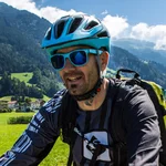 Gruppe von Radfahrern auf einem Landweg in grüner Berglandschaft