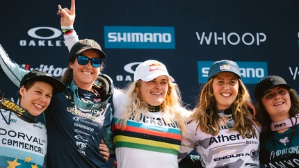 Glückliche Fahrerinnen mit Blumen und Trophäen auf dem Podium nach dem Rennen