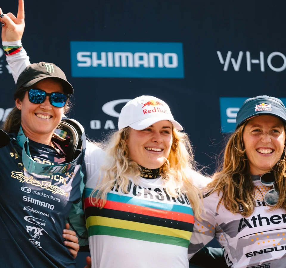Glückliche Fahrerinnen mit Blumen und Trophäen auf dem Podium nach dem Rennen