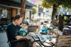 Vater und Tochter sitzen draußen an einem Cafétisch und essen gemeinsam.