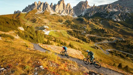Twee mountainbikers op pad in bergachtig landschap met rotsachtige toppen