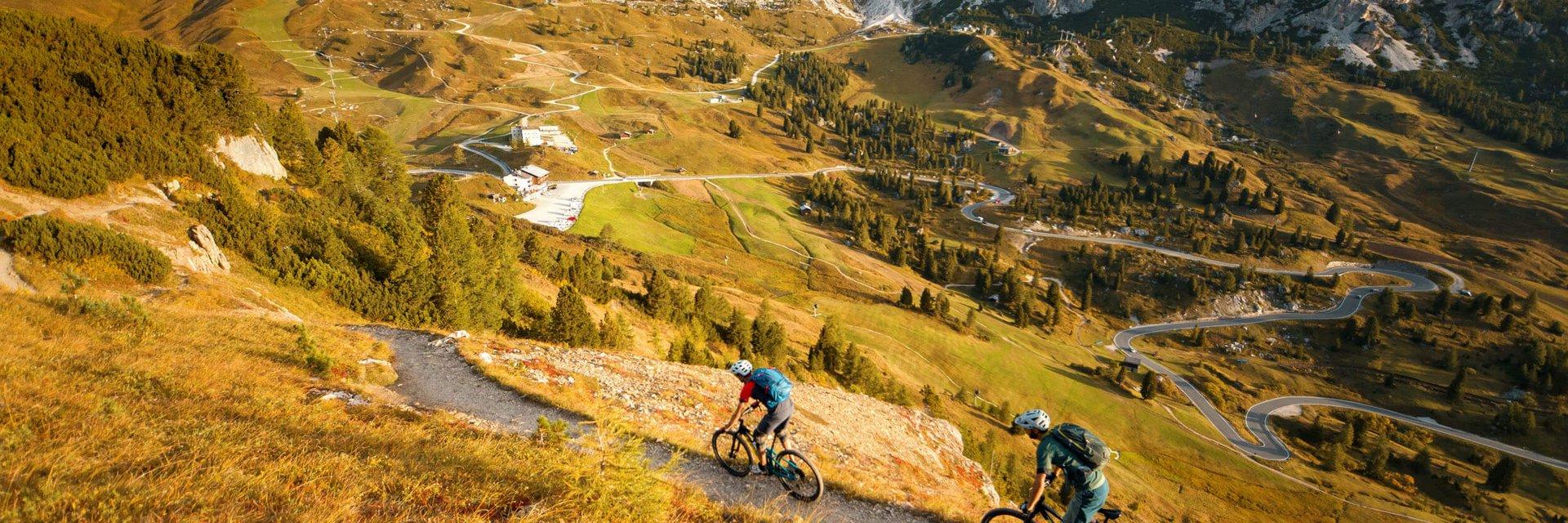 Zwei Mountainbiker auf Pfad in bergiger Landschaft vor Felsgipfeln