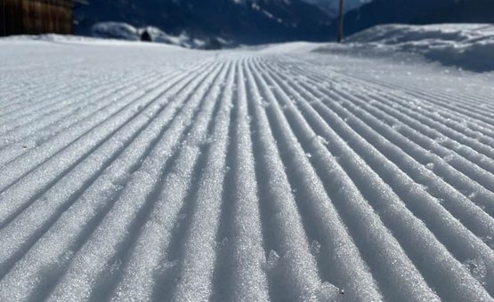 Groomed cross-country ski trail with mountains in the background