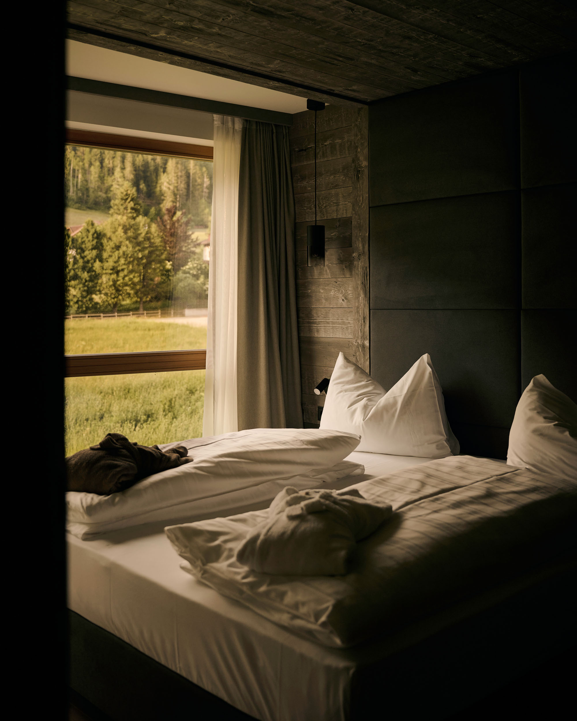 HIRBEN Naturlaub **** © David Rasche Cozy bed with white pillows and blankets next to window overlooking green landscape