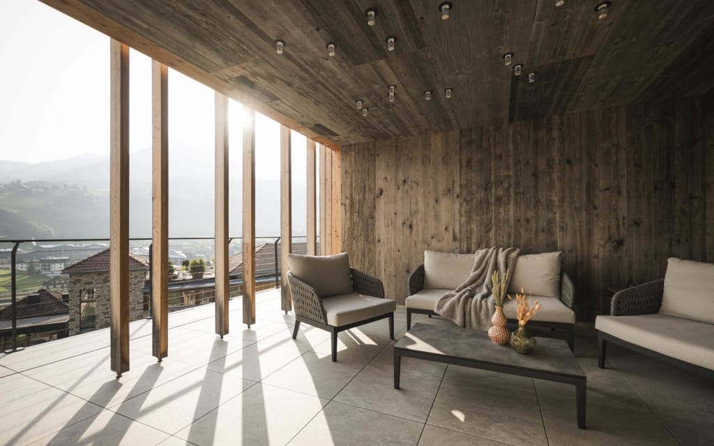 Cozy terrace with lounge furniture and mountain view in sunlight