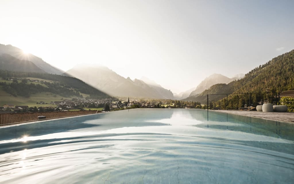 Summer Feeling Infinity pool overlooking valley and mountains at sunset