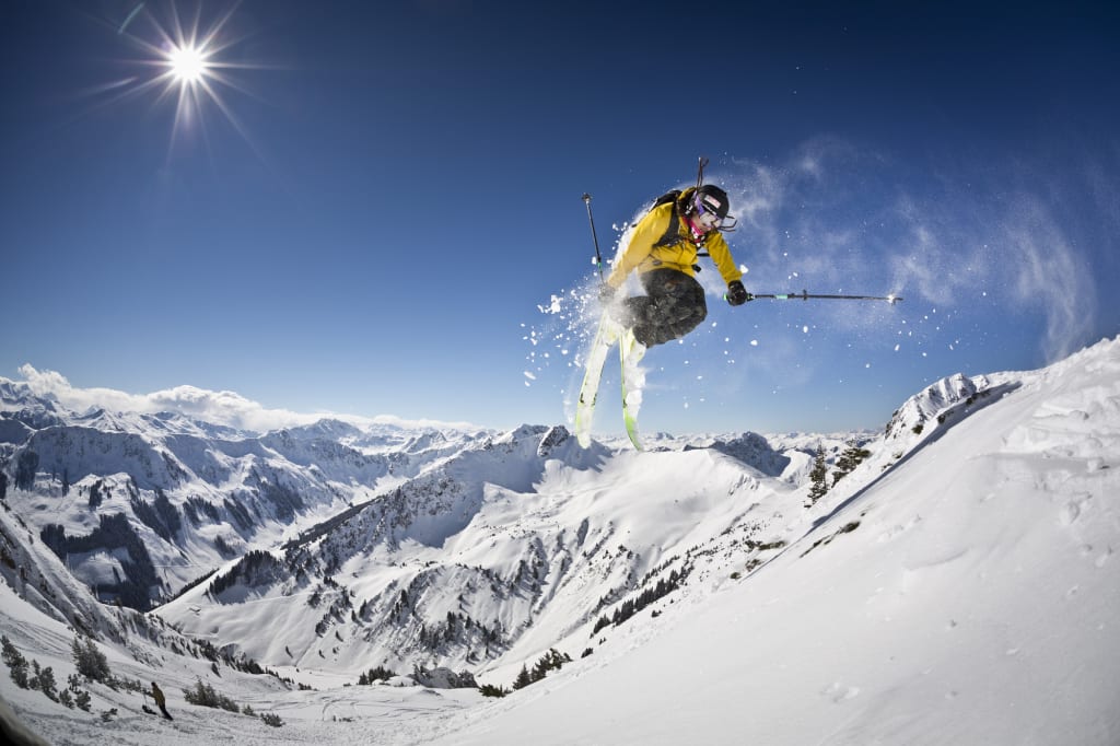 CLASSIC SKI Skifahrer springt auf verschneitem Berg bei sonnigem Himmel