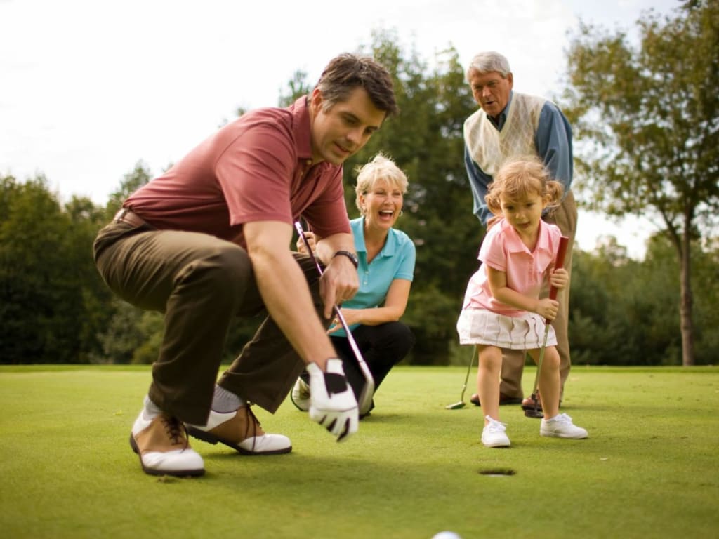"Golf & See" Unlimited Tage Familie spielt Golf auf dem Grün mit einem kleinen Mädchen und Großeltern