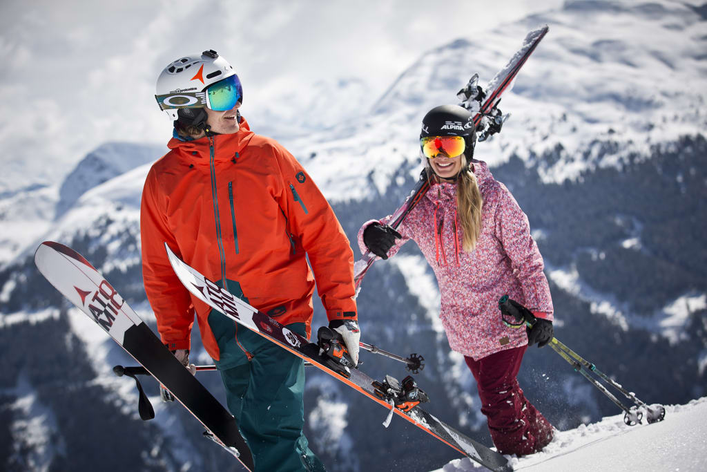 JÄNNER MIDWEEK SPECIAL Zwei Skifahrer mit Ausrüstung auf verschneitem Berg mit Bergen im Hintergrund