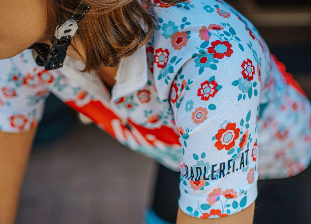 Ladylike Radmarathon Package - 2 nights Woman wearing floral cycling jersey with text padler.at on sleeve