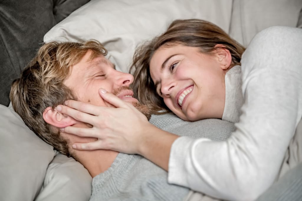 Glückliches Paar liegt nah beieinander auf dem Sofa