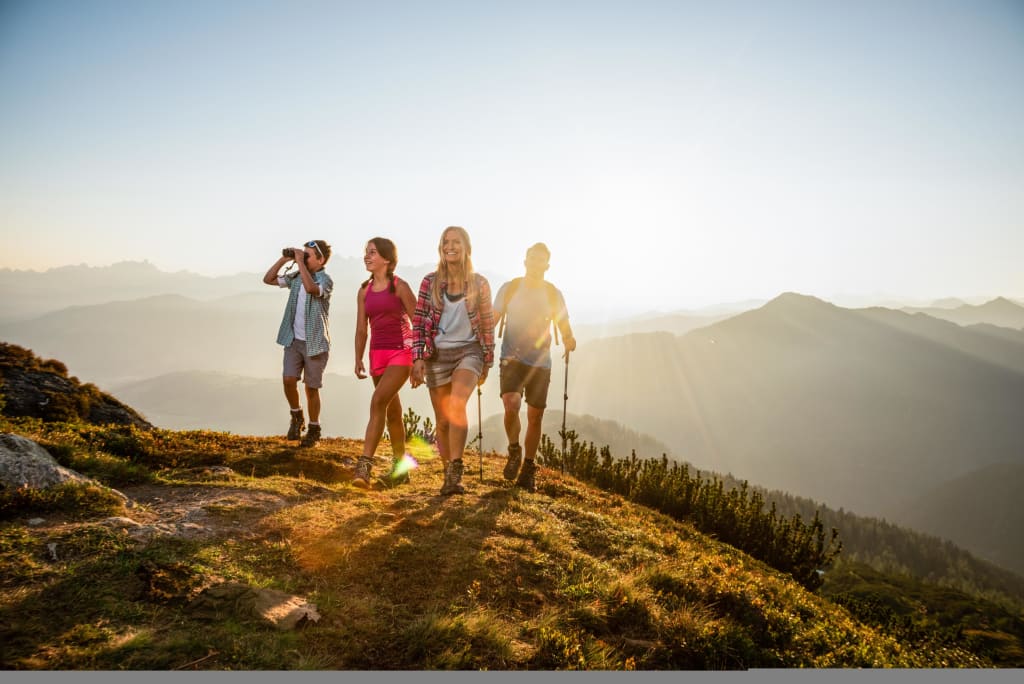 Vier Wanderer genießen eine Bergwanderung bei Sonnenuntergang