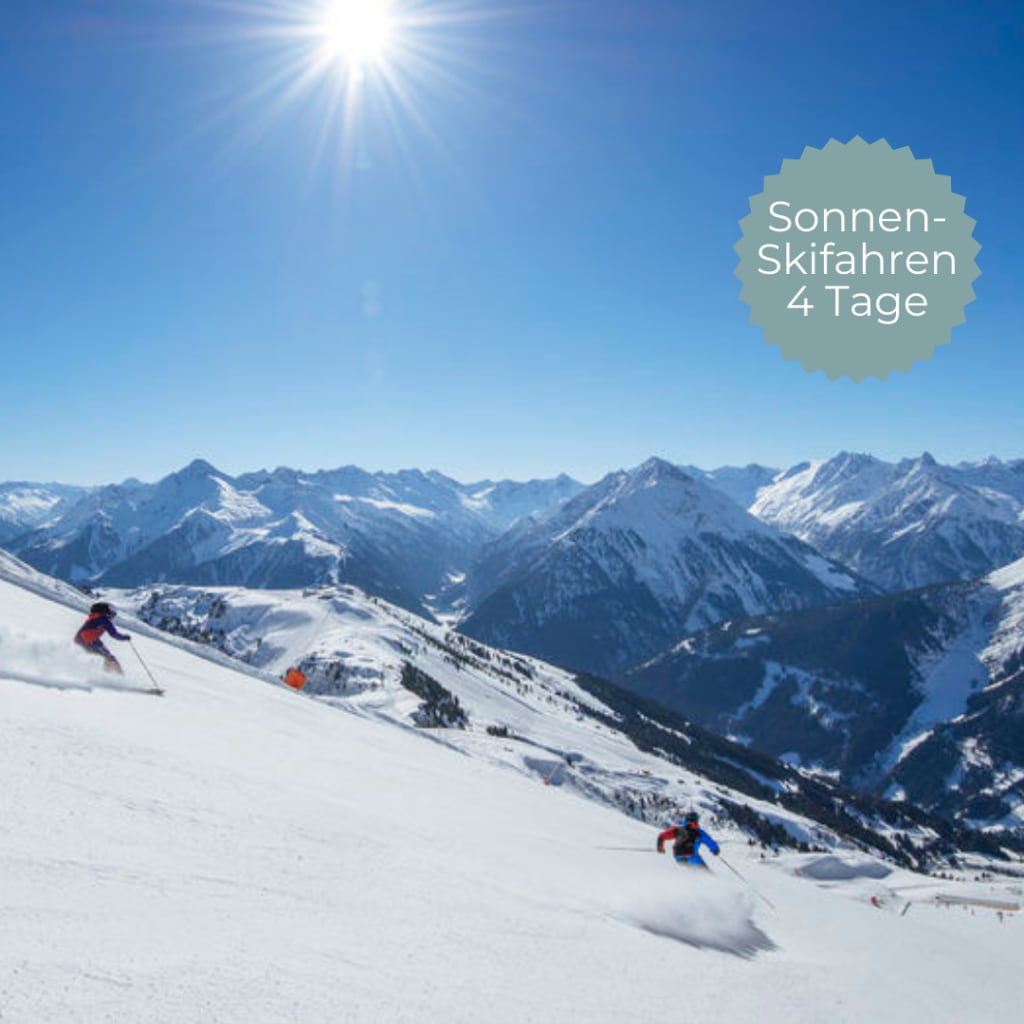 Skifahrer fahren an einem sonnigen Tag in schneebedeckten Bergen