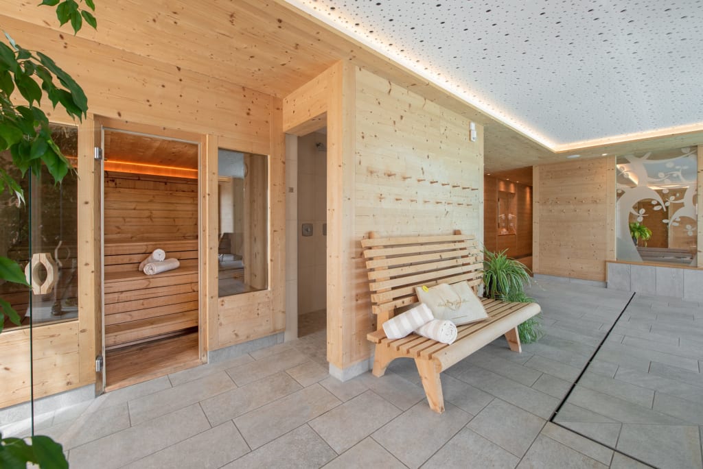 Saunabereich mit Holzwänden, Bank und Handtüchern in modernem Spa