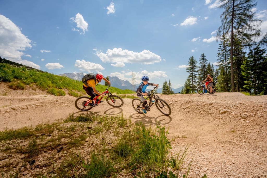 Two mountain bikers riding on a dirt trail in the mountains