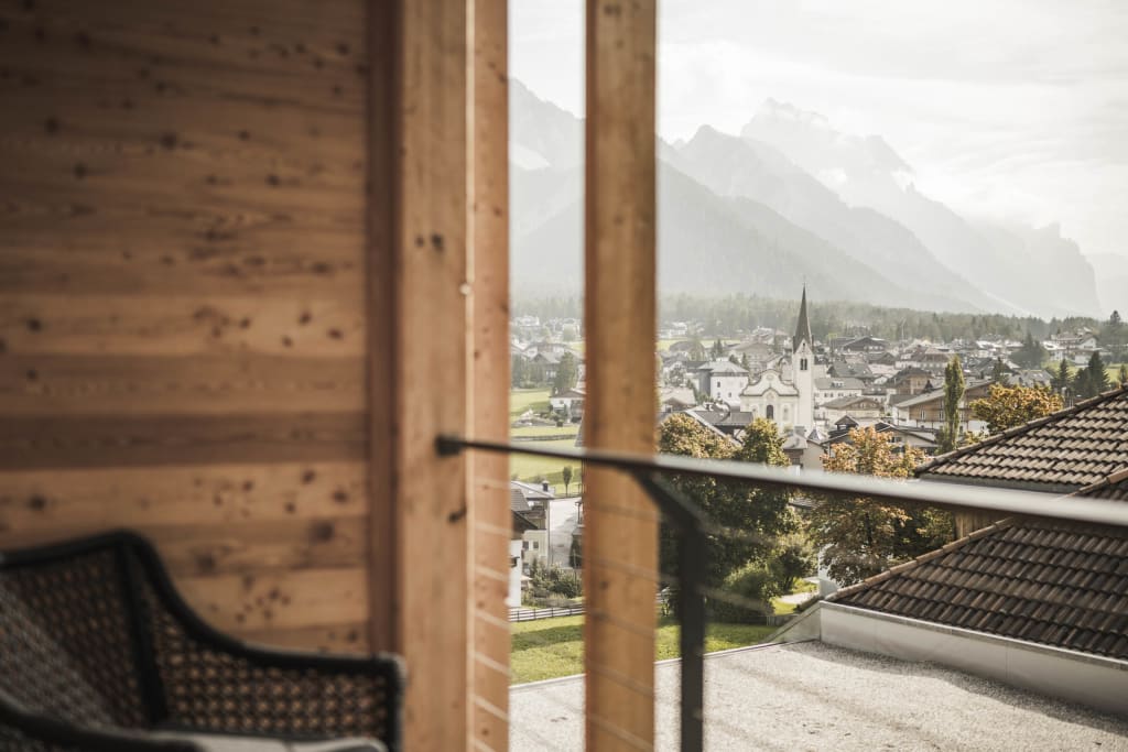 View from a balcony over a village with church and misty mountains