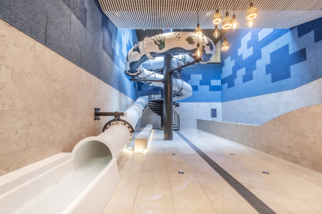 Modern water slide area with spiral slide in a blue and white room