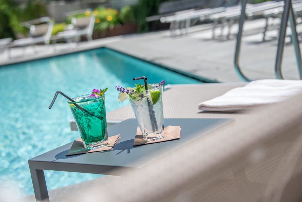 Zwei Cocktails auf einem Tisch neben einem Pool im Freien